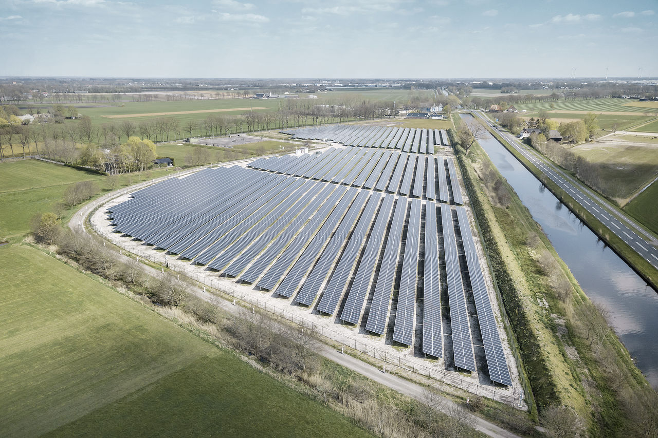 Luftaufnahme von einem Solarpark an einem Fluss