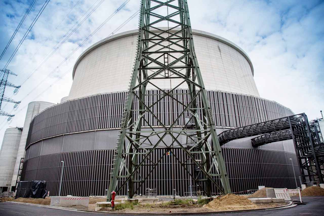 Eine Stromtrasse steht vor einem Kraftwerk