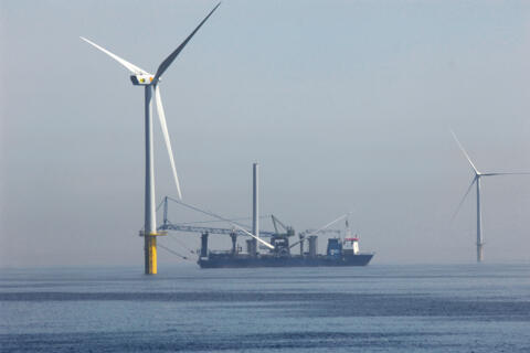 Ein Schiff liegt in einem Offshore-Windpark.