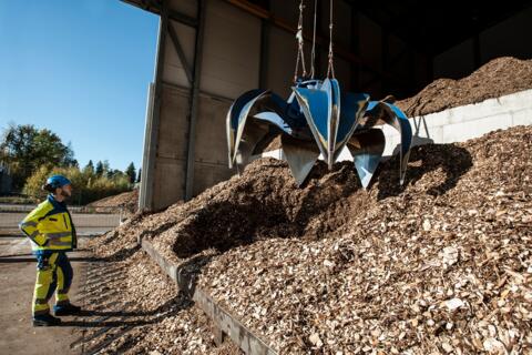 Construction worker watches as a crane picks up debris