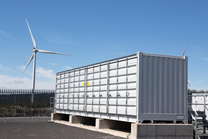 Windrad neben Batteriespeicher