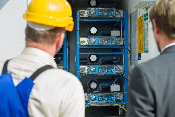 Stagebild Mitarbeiter vor Batteriespeicheranlage
