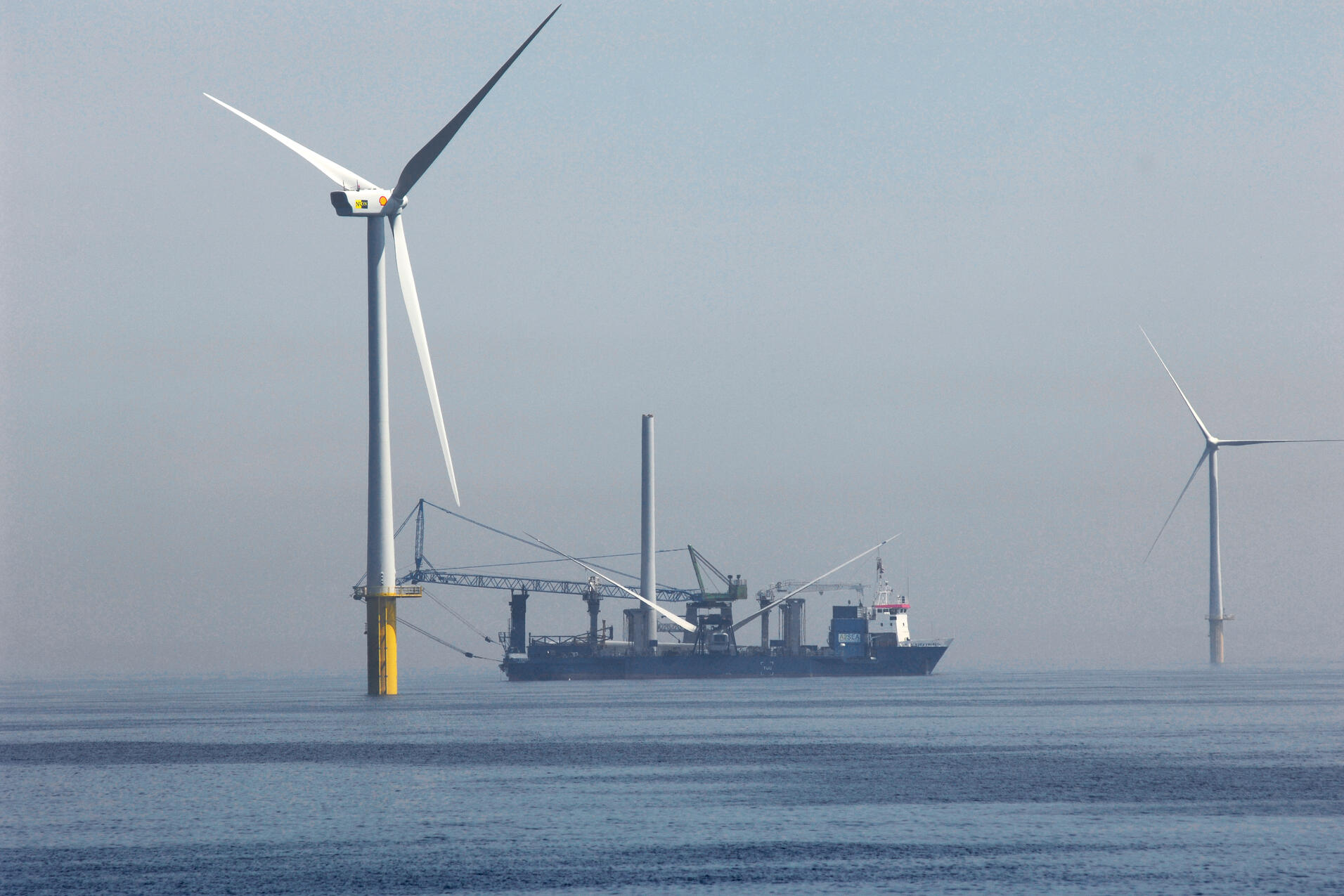 Ein Schiff liegt in einem Offshore-Windpark.