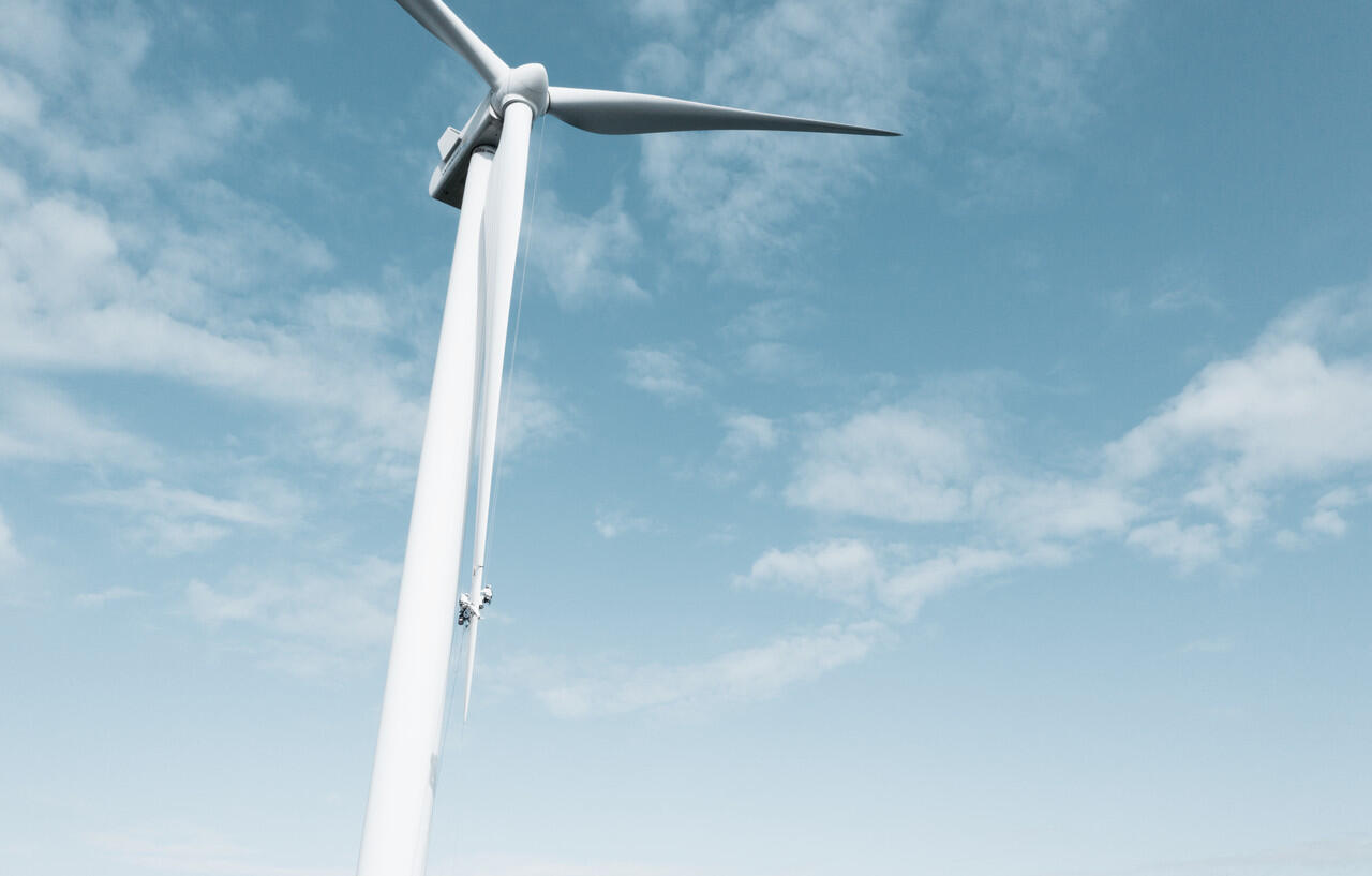 Ein Windrad vor blauem Himmel mit Wolken