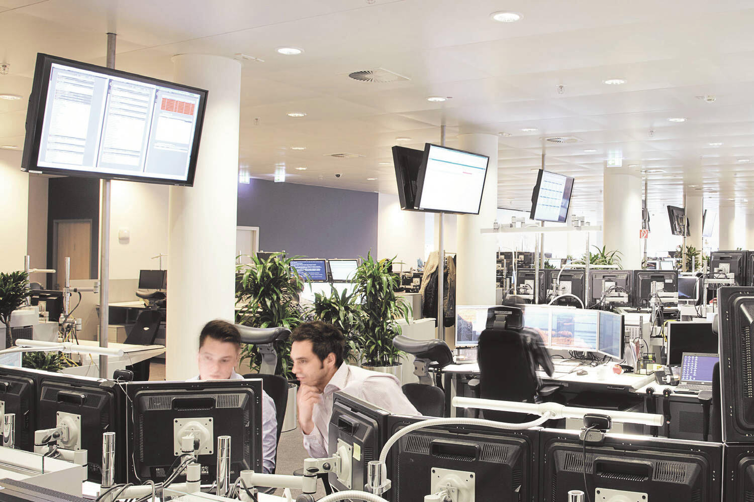 Stagebild Mitarbeiter und Bildschirme im Trading Floor