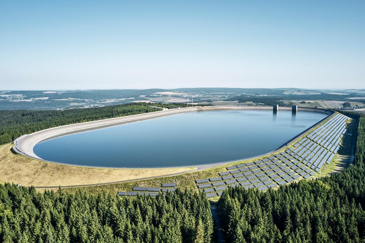 Pumpspeicherwerk mit Solarpaneelen umgeben von einem Wald.
