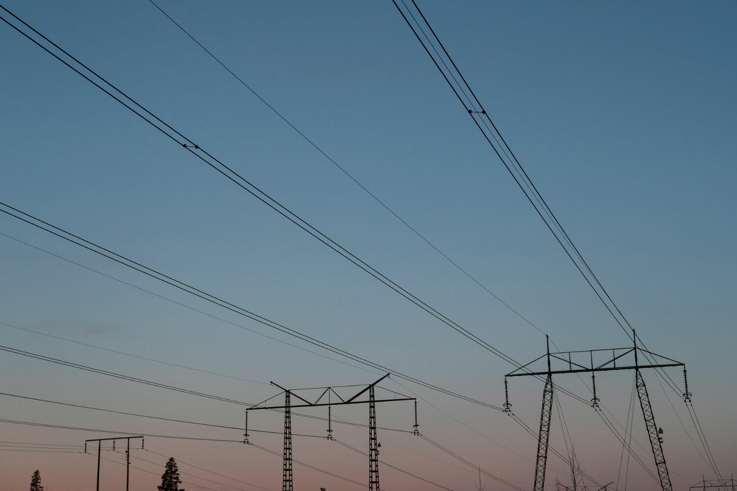 Freileitungsmasten aus Stahl beim Abendhimmel.