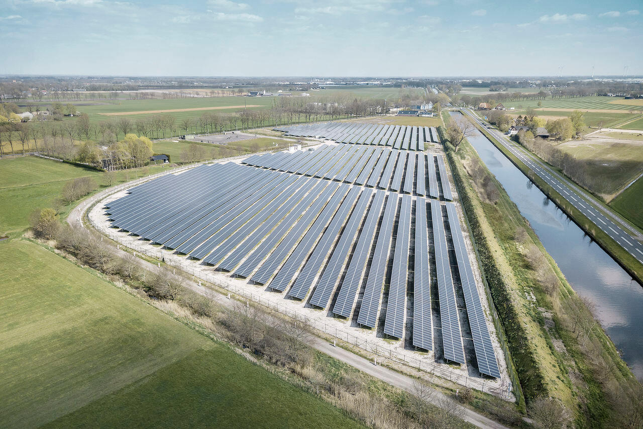 Luftaufnahme von einem Solarpark an einem Fluss